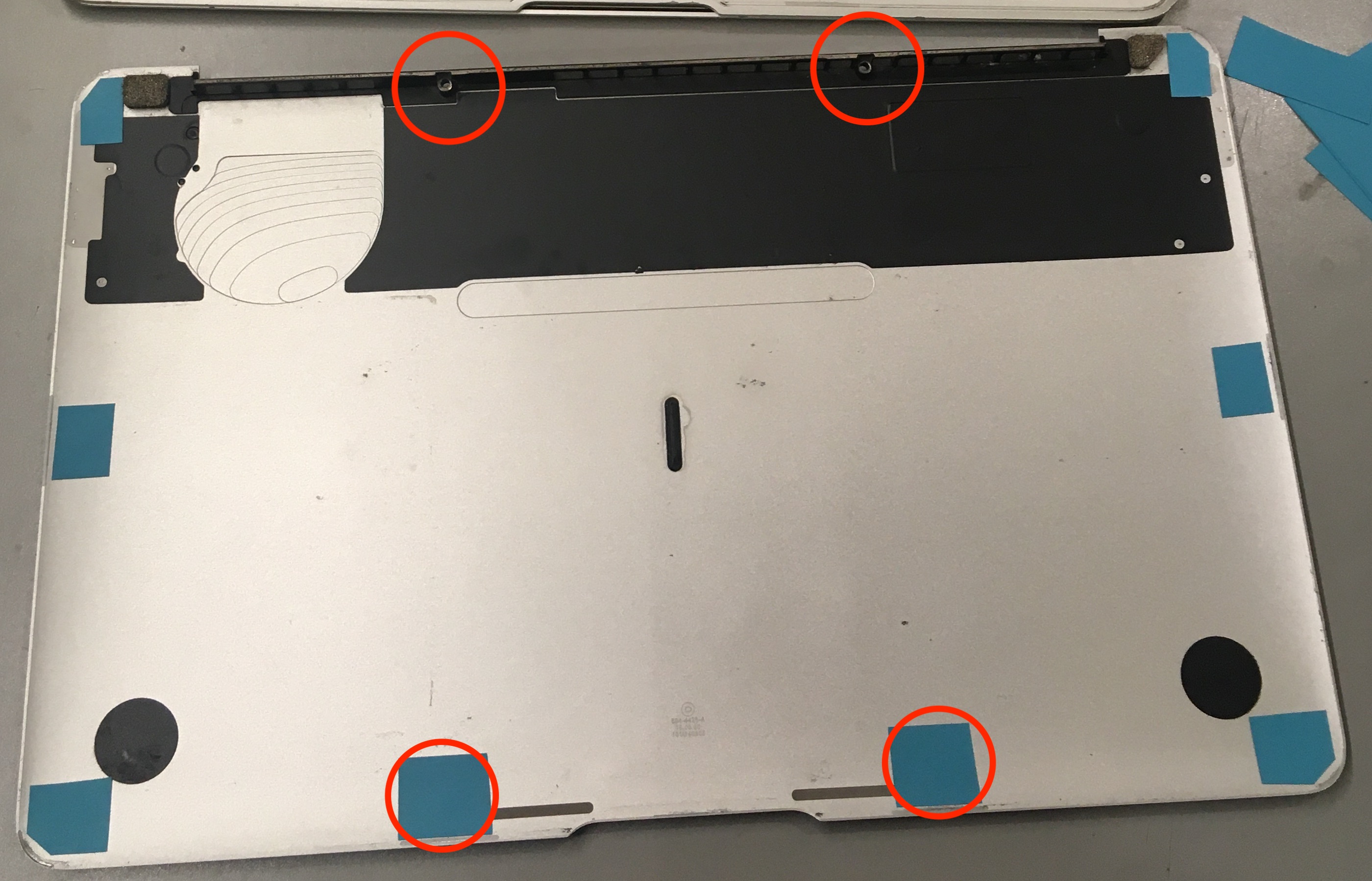 the bottom case, with little pieces of blue sticky notes and the middle four screw holes circled